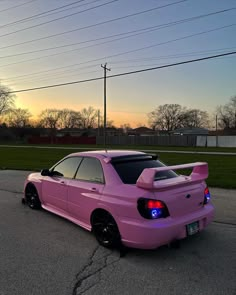 a pink car is parked on the street