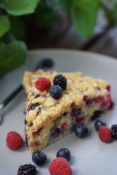 a slice of berry crumb cake on a plate with berries