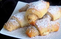 powdered sugar covered croissants on a white plate