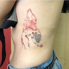 a woman with a tattoo on her stomach has a wolf holding a ball in her hand