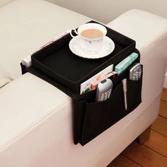 a coffee cup and magazine holder on a white couch