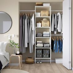 an organized closet with clothes, shoes and other items on shelves next to a bed