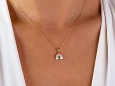 This 14K gold rainbow necklace is a colorful and dainty piece of jewelry that would make a beautiful gift for any occasion. The rainbow pendant is a symbol of friendship and pride, and would be a thoughtful present for a loved one on Christmas, Father's Day, Mother's Day, Valentine's Day, an anniversary, or a birthday. The necklace is a choker style and would sit close to the neck, making it perfect for layering with other necklaces or wearing on its own. It would make a lovely addition to any j Handmade Rainbow Necklaces For Everyday Wear, Handmade Rainbow Necklaces For Everyday, Handmade Rainbow Necklace For Everyday, Colorful Necklace With Adjustable Chain As Gift, Colorful Jewelry With Adjustable Chain As Gift, Colorful Jewelry With Adjustable Chain For Gifts, Colorful Adjustable Chain Jewelry As Gift, Colorful Adjustable Chain Jewelry Gift, Multicolor Personalized Dainty Jewelry