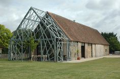 an old barn with a metal frame on the roof