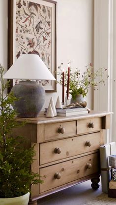 a wooden dresser with a lamp on top of it