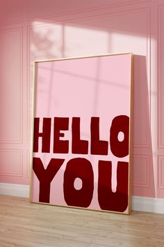 a red poster with the words hello you on it in front of a pink wall