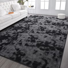 a living room with a white couch and black rug