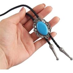 a hand holding a blue stone and metal object