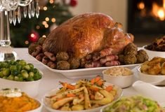 a large turkey sitting on top of a table next to bowls of vegetables and other foods