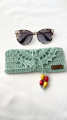 a pair of sunglasses sitting on top of a knitted headband