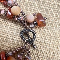 This rustic, beautiful multi-strand bracelet is made from three strands of large aventurine chips, copper/gray faceted rondelles, rust-colored bicones, copper spacers and frosted gold glass rounds. The heart toggle is completed with two beaded dangles. All metals are nickel and lead free. Multi Strand Bracelet, Bracelet Earring Set, Strand Bracelet, Gold Glass, Rust Color, Beaded Dangles, Amber Glass, Multi Strand, Earrings Set