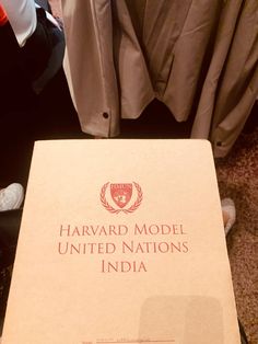 the harvard model united nations india book sits on a table in front of some clothes