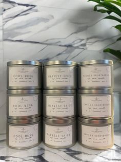 five tins of candles sitting on top of a marble counter