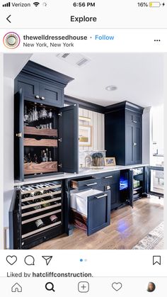 an instagramted photo of a kitchen with blue cabinets and wine racks in it