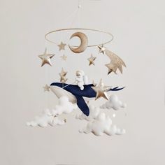 a baby mobile with stars and a whale in the sky