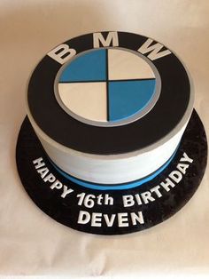 a birthday cake that is decorated with the bmw logo on it's bottom layer