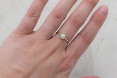 This stunning minimalistic ring features a lab created white opal set in a delicate yellow gold filled bezel setting. The band is the perfect balance of minimalist and durable. The dainty ring looks gorgeous by itself or stacked with other rings!  Setting Details-Material: 14/20 Yellow Gold FilledBand Width: 1.7mmGemstone Details- Gemstone: OpalType: Lab CreatedColor: WhiteSize: 6mm Shape: RoundAs with any gemstone, there can be some variation in color and tone.The ring ships in a custom ring bo Minimalistic Ring, Gold Ring Stacking, Pink Opal Earrings, Gold Opal Ring, Delicate Gold Ring, Custom Ring Box, Malachite Rings, Opal Ring Gold, Opal Studs