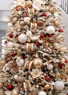 a white christmas tree with red and gold ornaments