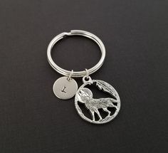 a keychain with a wolf on it and a letter i in the middle