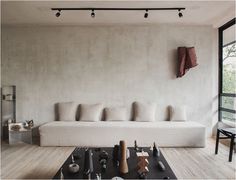 a living room with a white couch and various objects on the table in front of it