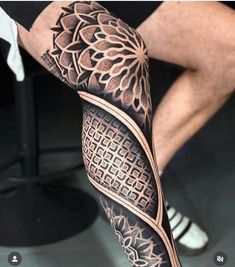 a man's leg with an intricate tattoo design on the arm and leg area