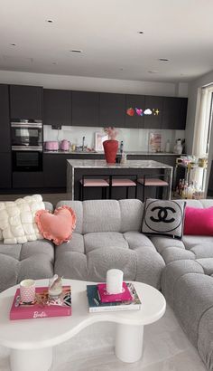 a living room filled with furniture and a white table in front of a large window