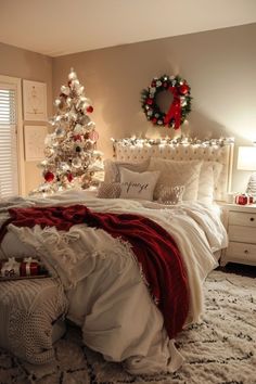 a bedroom decorated for christmas with a tree and wreath