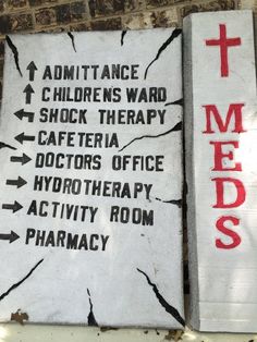 two signs on the side of a building that say meds, admittance, children's ward and shock therapy