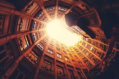 looking up at the sky through a circular window in an old building with many windows