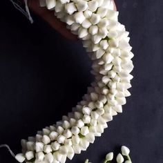 a bunch of white flowers sitting on top of a black table next to some string