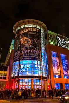 people are standing in front of an illuminated building