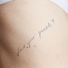 the back of a woman's stomach with writing on it that says, find your peace