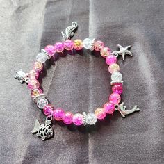 This Super Cute Bracelet Can Double As An Ankle Bracelet As Well. Really Cute By Itself Or If You Stack With Other Pieces. The Beads Are Lamp Work Crackle Glass And The Charms Are Metal. This Was Measured Out To 10 Inches Before I Tied It Off. Should Fit Around 8 To 10 Inch Ankle. Casual Pink Handmade Anklet, Adjustable Colorful Beads Charm Bracelet For Beach, Silver Strand Bracelets For Summer, Beaded Stretch Bracelet For Vacation, Casual Silver Bracelets For Beach, Vacation Beaded Stretch Bracelet, Handmade Adjustable Crystal Bracelet For Beach, Casual Silver Strand Jewelry, Casual Pink Beaded Charm Bracelet