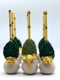 there are three balls with gold decorations on them and one has an elephant's head