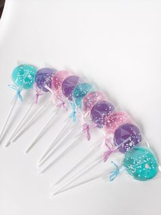 a bunch of little mermaid lollipops sitting on top of a white table