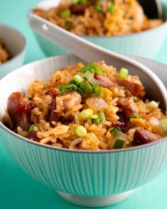 two bowls filled with rice and meat on top of a blue table