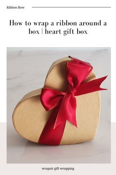 a heart shaped box with a red ribbon on it and the words how to wrap a ribbon around a box / heart gift box