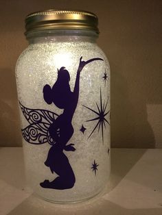 a glass jar with an image of a fairy on the front and stars in the back