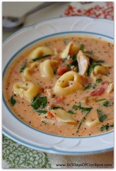 a bowl of soup with pasta and spinach