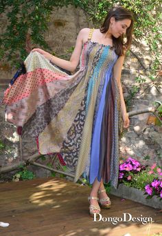 a woman standing on a wooden deck wearing a dress with different colors and patterns,