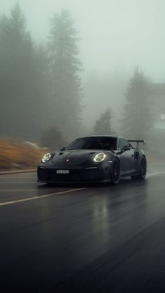 a black sports car driving on a wet road