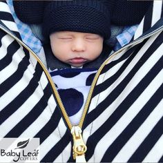 a baby wearing a black and white striped jacket with a hat on it's head