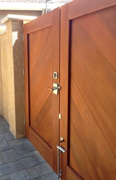 two wooden doors are open on the side of a house