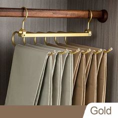 the gold curtain rod is hanging on the wall next to some beige and tan curtains