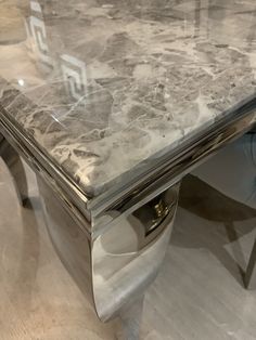 a marble top table with chrome legs on display