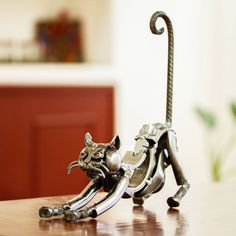 a metal cat figurine sitting on top of a wooden table