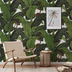 a chair and table in front of a wall with a palm tree mural on it