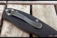 a black knife sitting on top of a wooden table