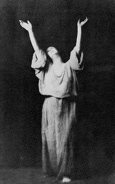 an old black and white photo of a woman with her arms in the air