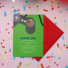 a card with a video game controller on it next to confetti and streamers